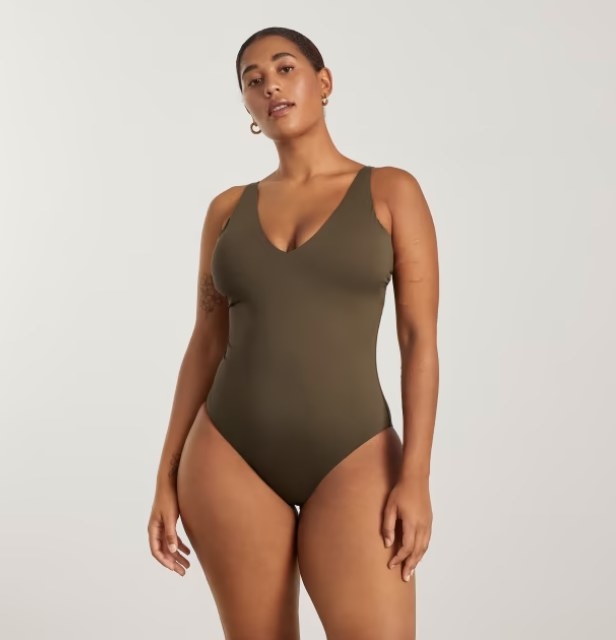 A model wearing an olive green v neck one piece
