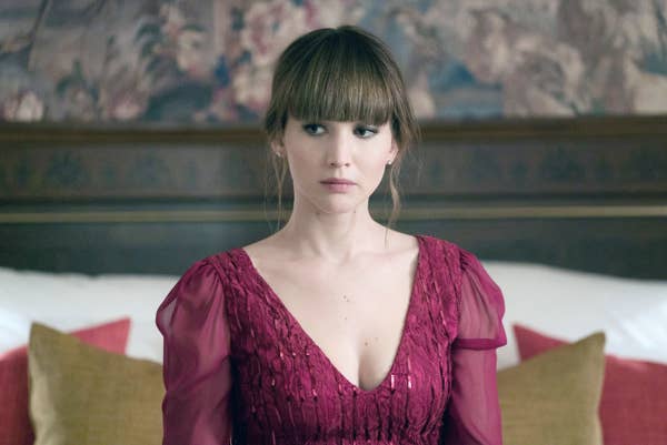 Jennifer Lawrence in a gown sitting in a fancy room