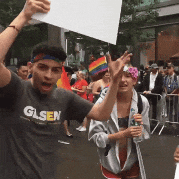 people celebrating with signs at pride parade