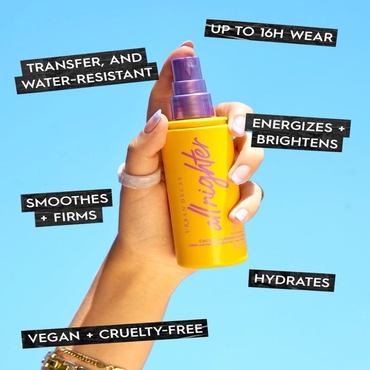 A person holding up a bottle of the setting spray