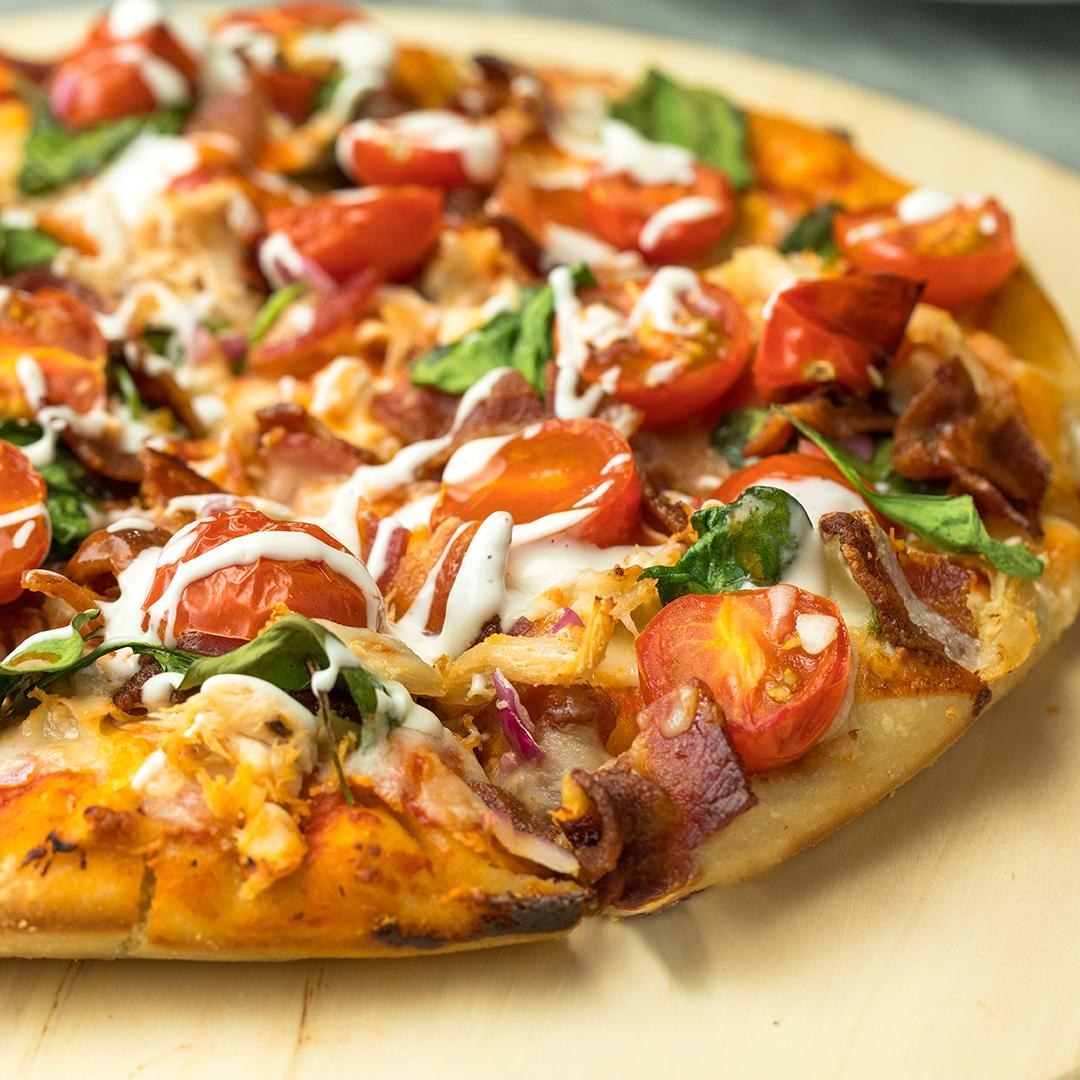 close up of a pizza with cherry tomatoes and chicken