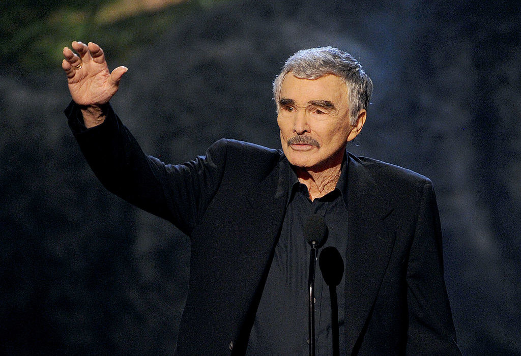 Burt at a microphone waving