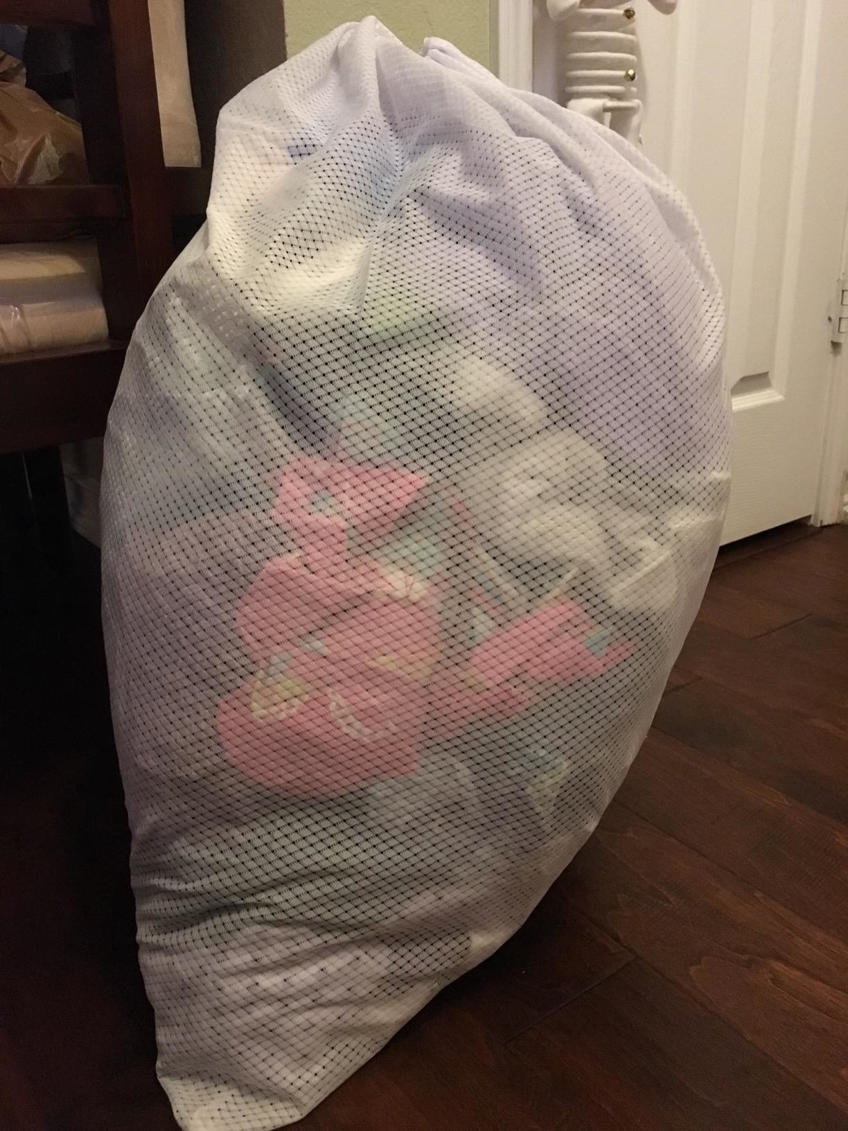 reviewer's photo of the laundry bag holding a large quantity of clothes