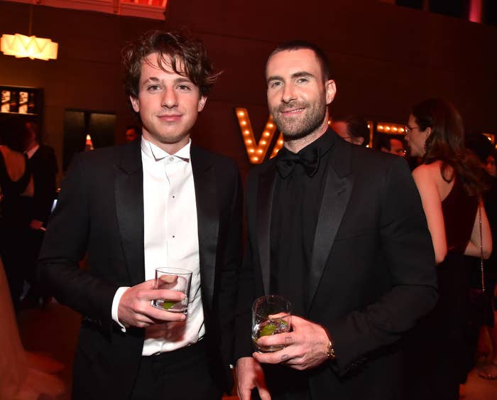 Charlie and Adam in tuxes standing together and holding drinks