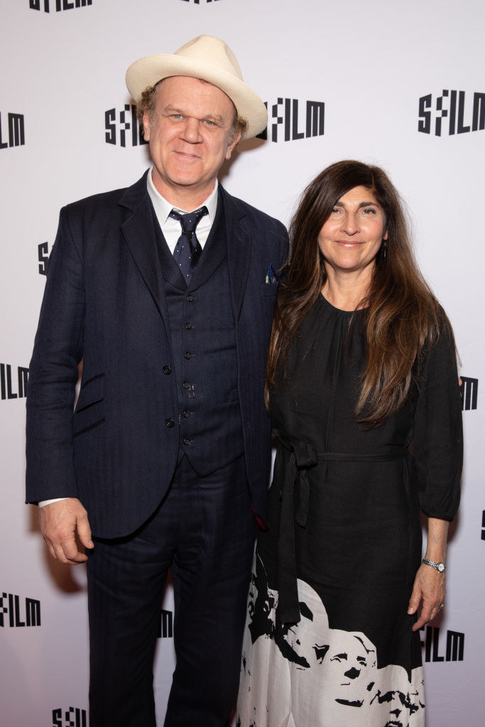 John in a wide-brimmed hat and Alison on the red carpet