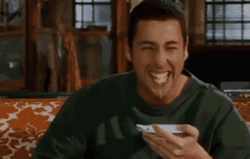 Adam Sandler laughing while eating cereal