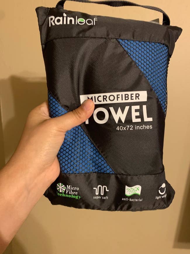 reviewer holding the towel folded up in a compact carry bag