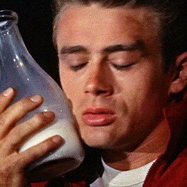 James Dean resting his cheek on a jar of milk