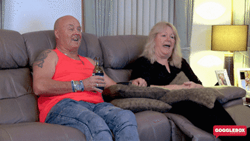 couple laughing at something on tv