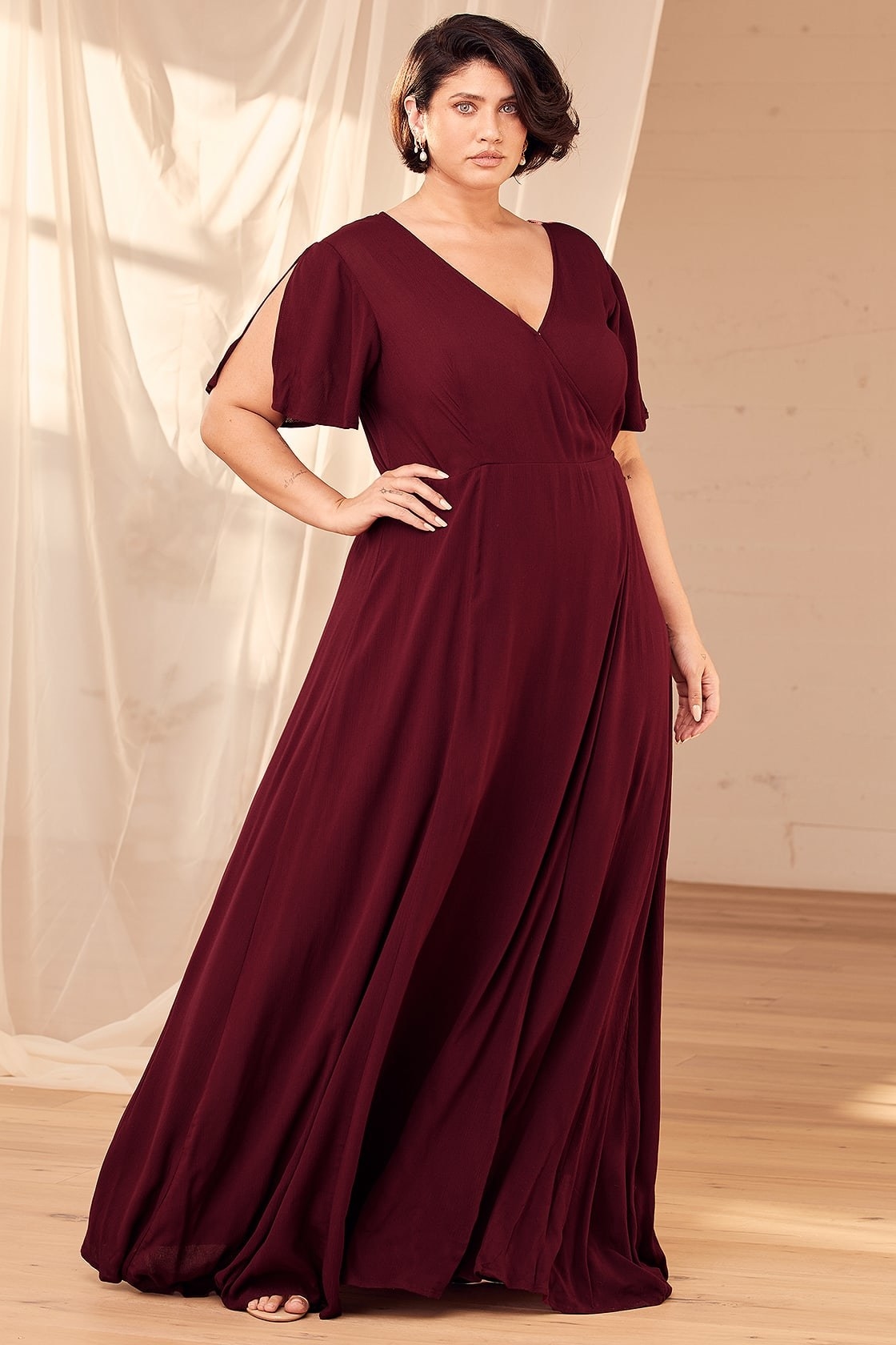Model is wearing a burgundy wrap dress