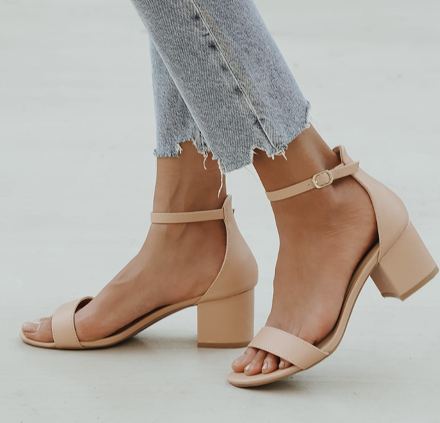 The light beige block heel sandals on a model&#x27;s feet