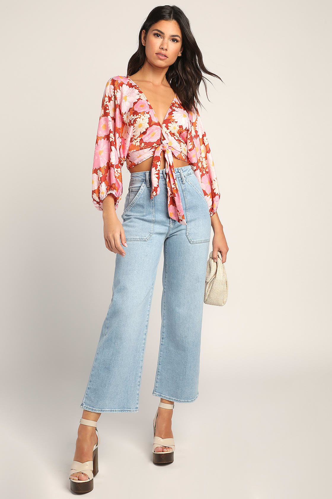 Model is wearing wide-leg denim jeans, platform heels and a floral top