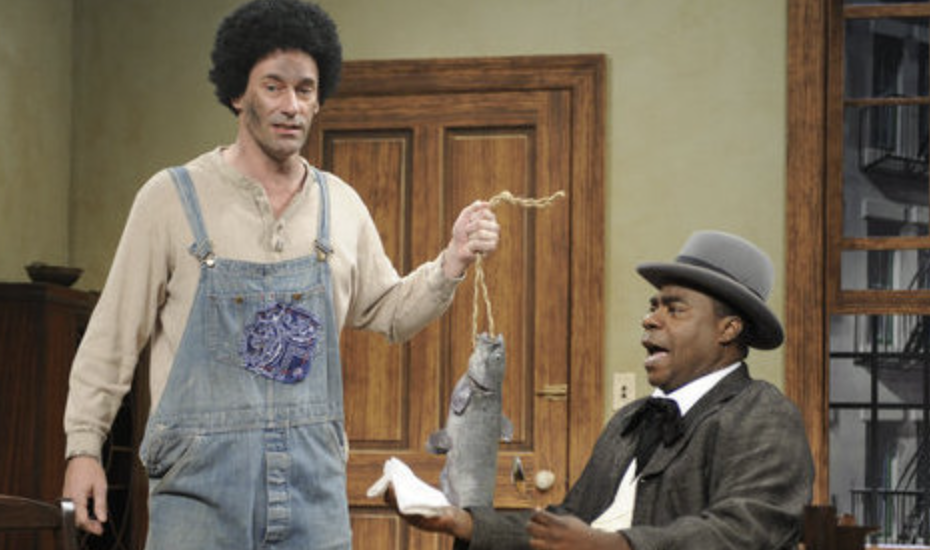 a character in blackface holding a fish in front of tracy morgan&#x27;s character