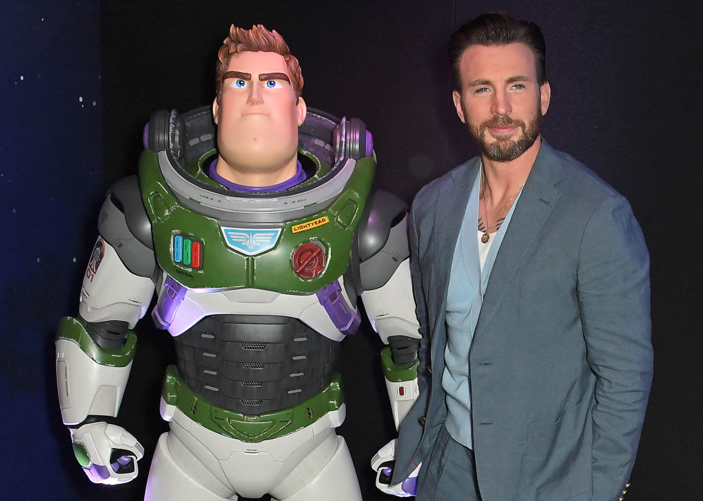 Chris Evans posing with a full-size version of the Buzz Lightyear he plays