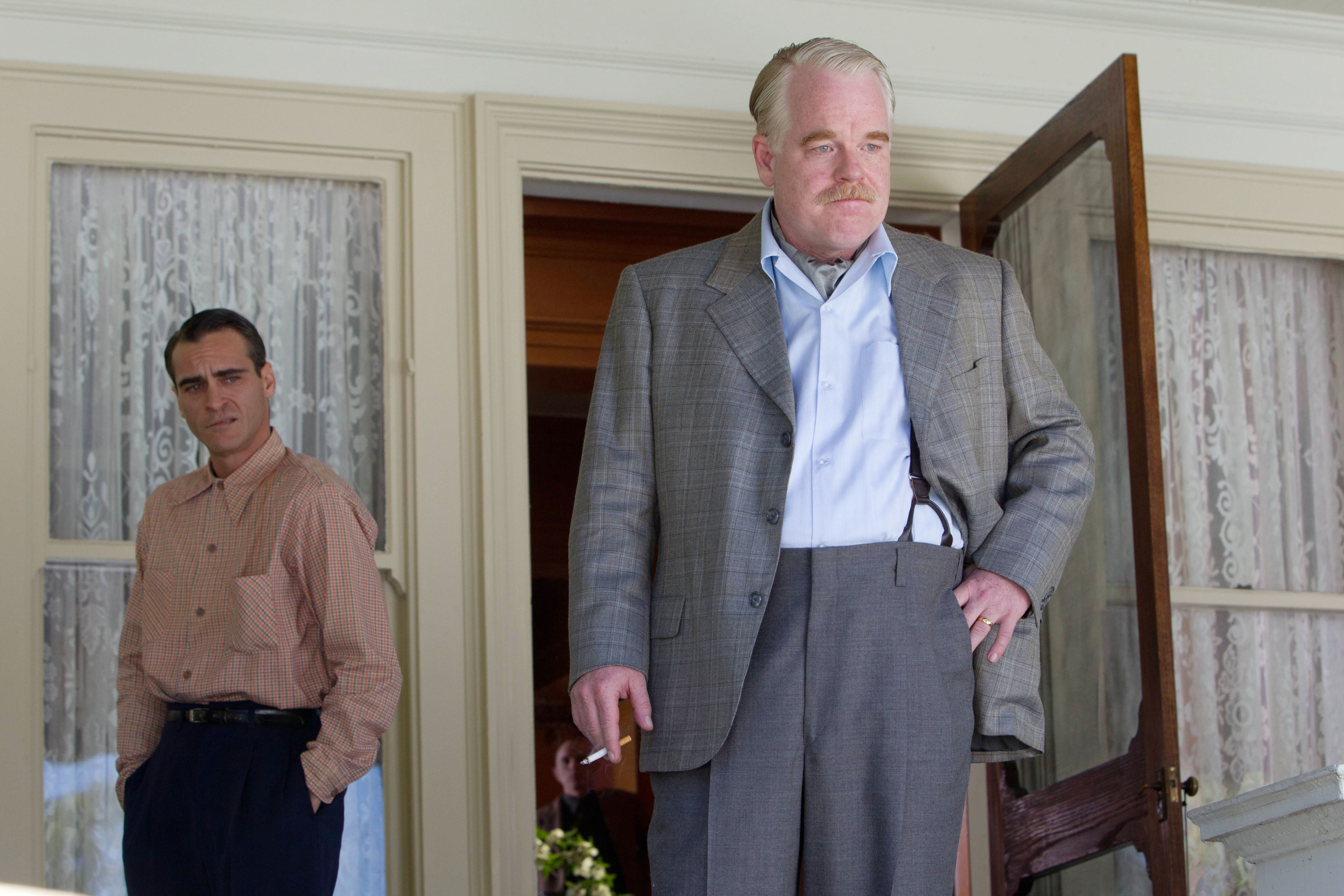 Joaquin Phoenix, Philip Seymour Hoffman standing on a porch