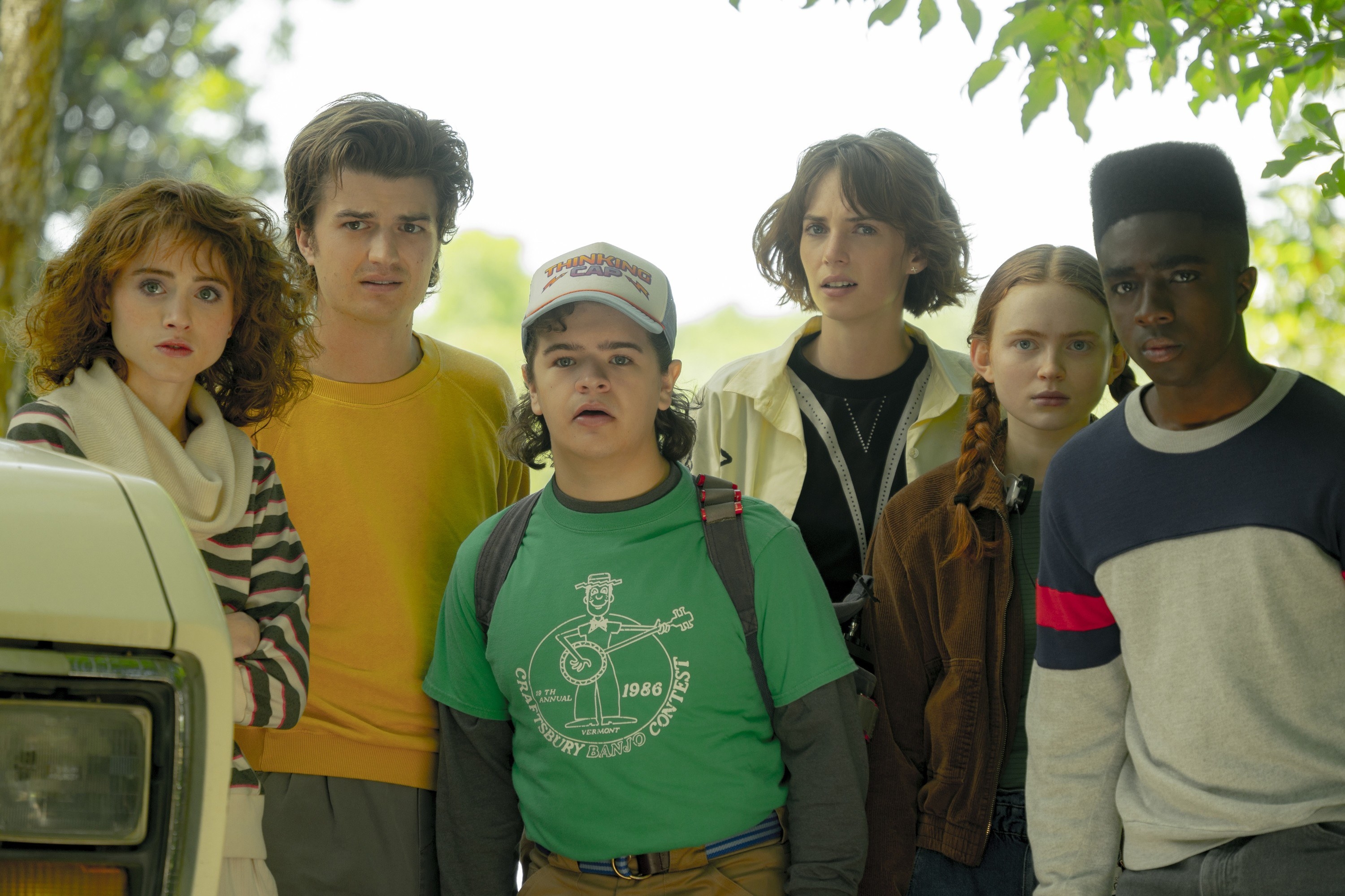 the kids from &quot;Stranger Things&quot; standing outside and looking at something together