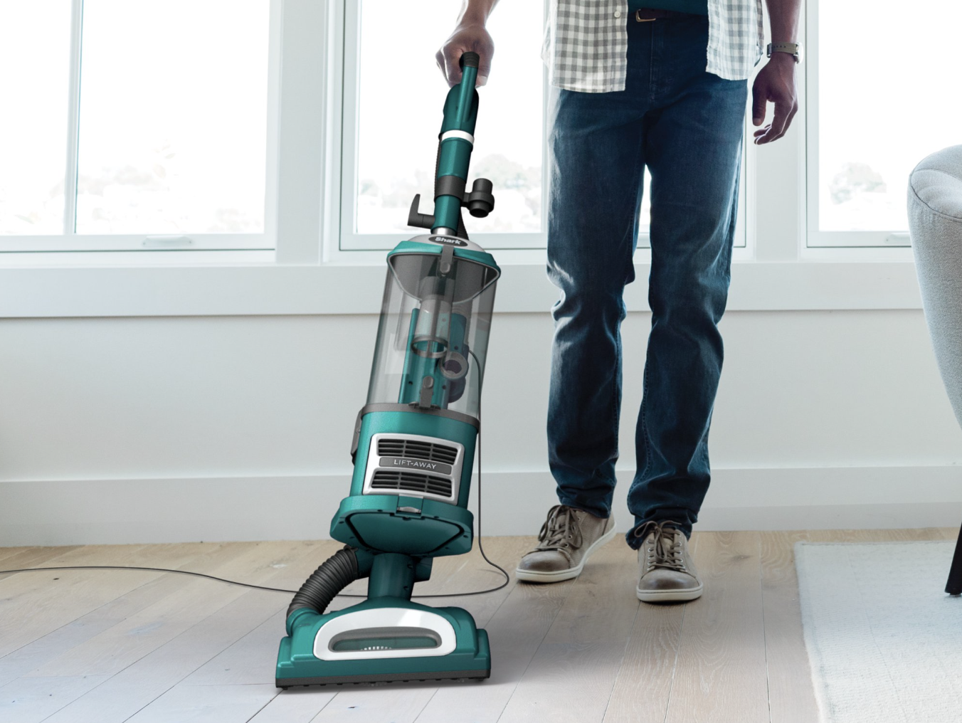 model uses green Shark Navigator vacuum to clean hardwood floor