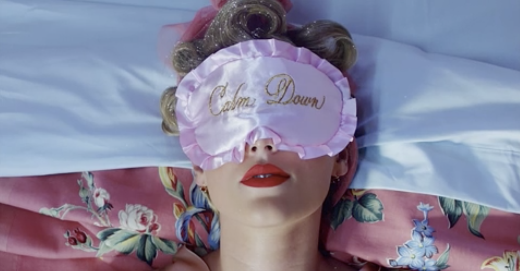 Taylor Swift wearing a sleep mask and sleeping on a bed