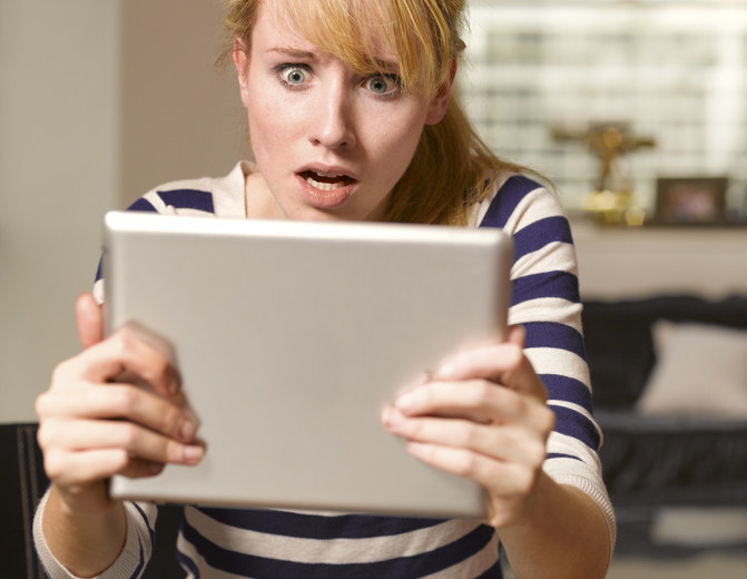 woman in shock looking at an ipad