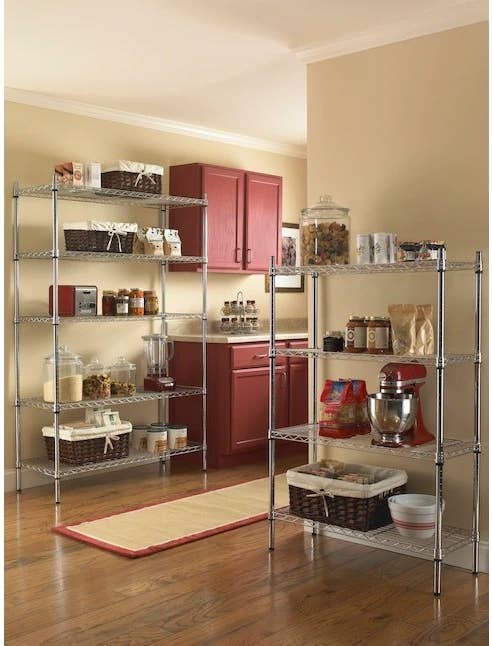 A five-tier steel utility shelving unit in a kitchen holding kitchen items
