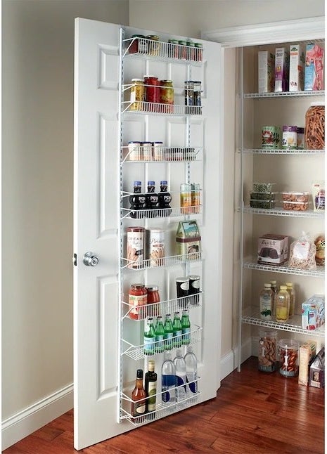 an eight-tier hook-on metal door organizer inside a pantry holding snacks