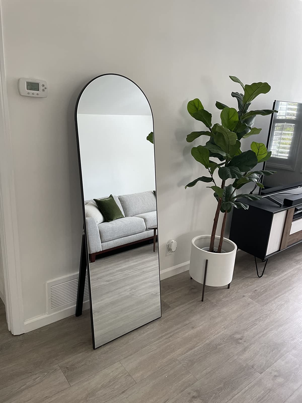 Reviewer&#x27;s floor mirror is shown leaning against a living room wall