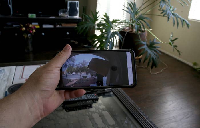 a person holding their phone with the camera view of the front porch