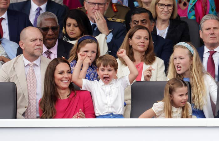 An excited Prince Louis with his arms raised