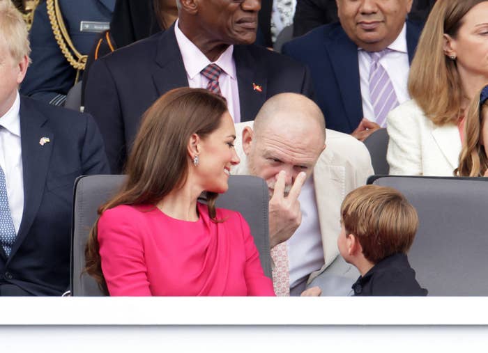 The Duchess of Cambridge smiling as Mike gestures at Prince Louis