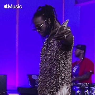 Rapper 2 Chainz throwing money with a Dj in the back of him
