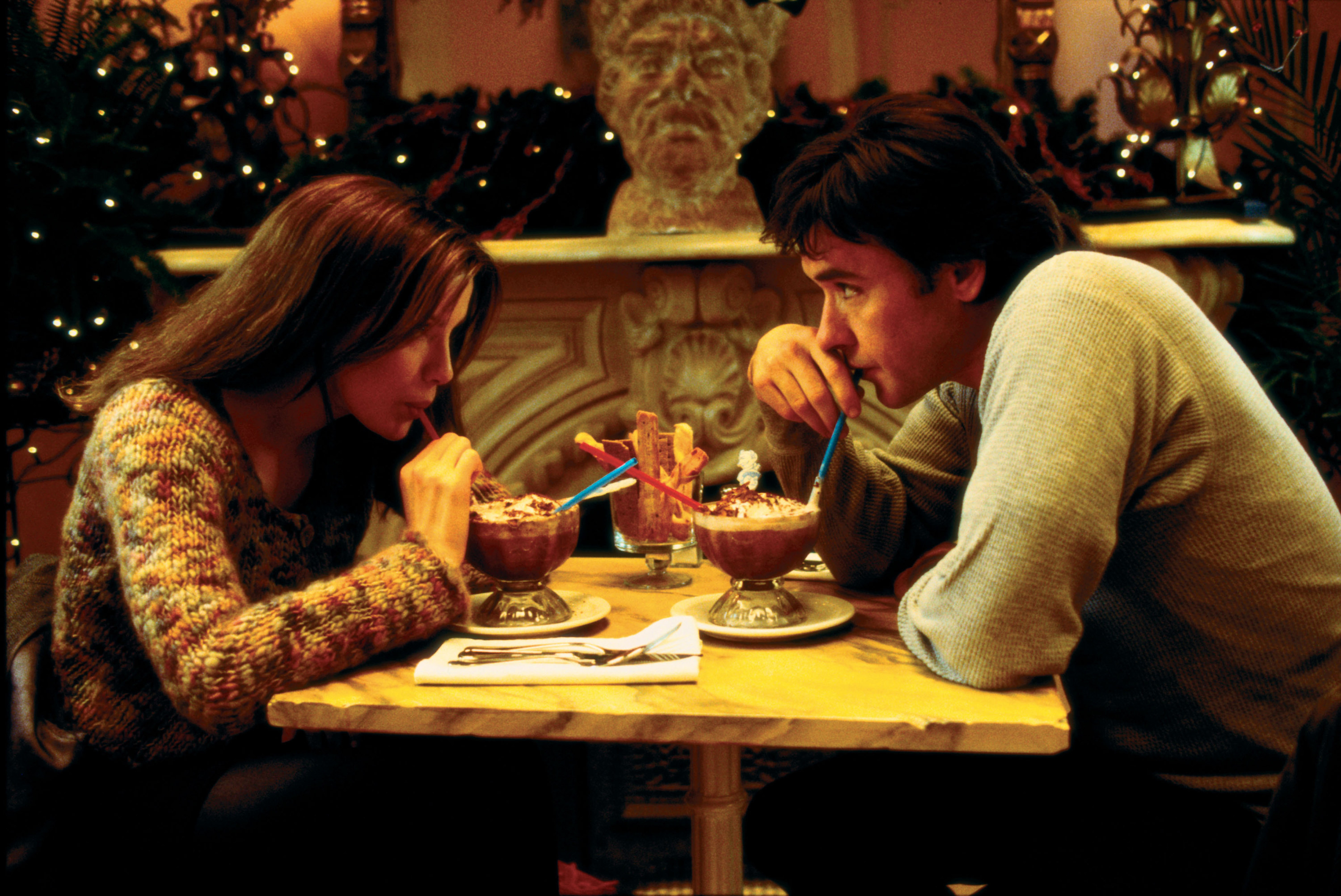 john cusack and kate beckinsale drinking forzen hot chocolate at a table in serendipity