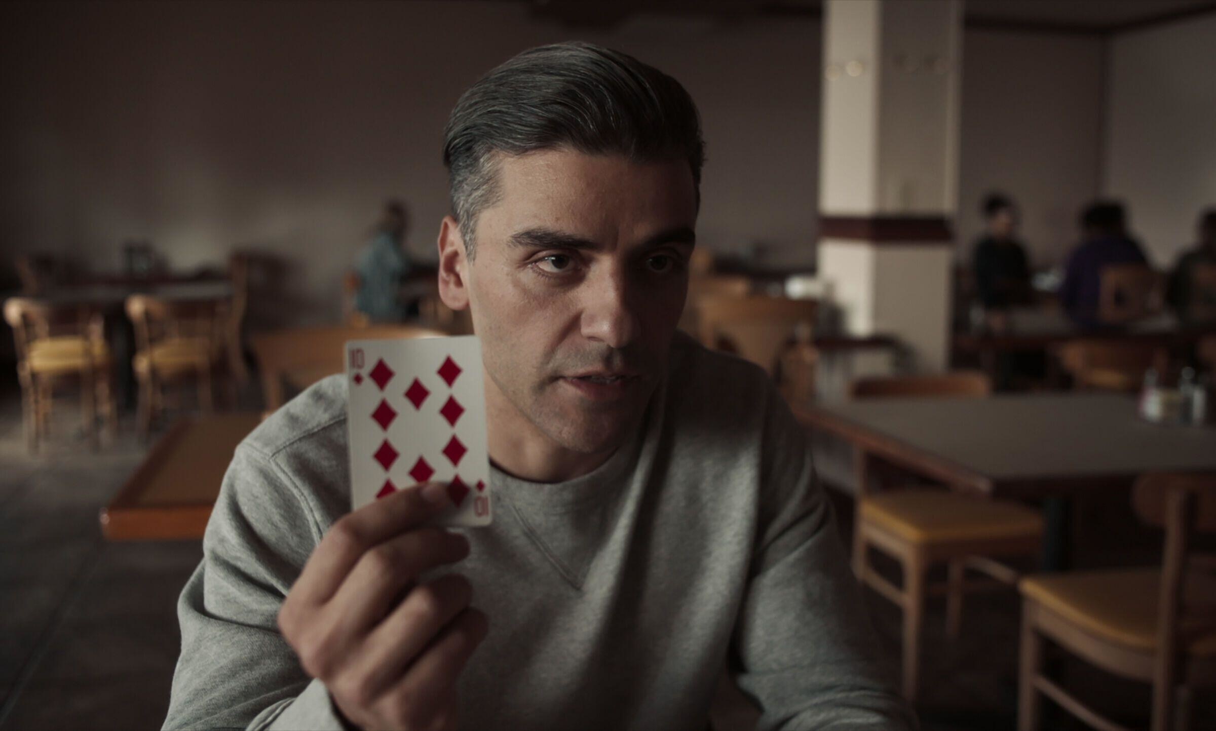 oscar isaac holding up a playing card