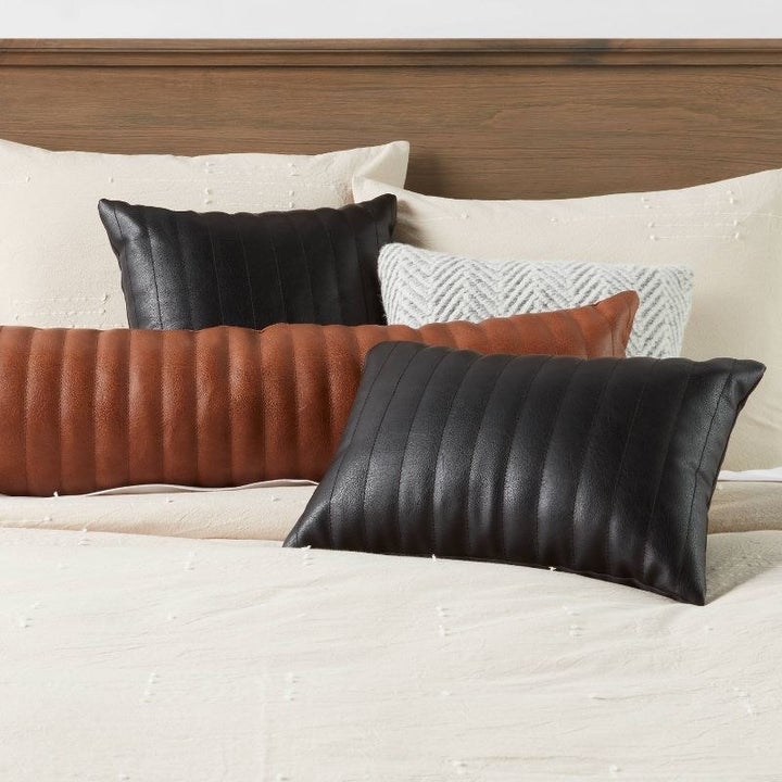 An image of lumbar faux leather pillows with channel stitch detailing