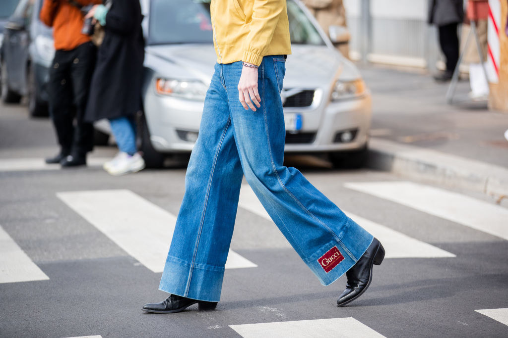 A person walking on the street in flared jeans
