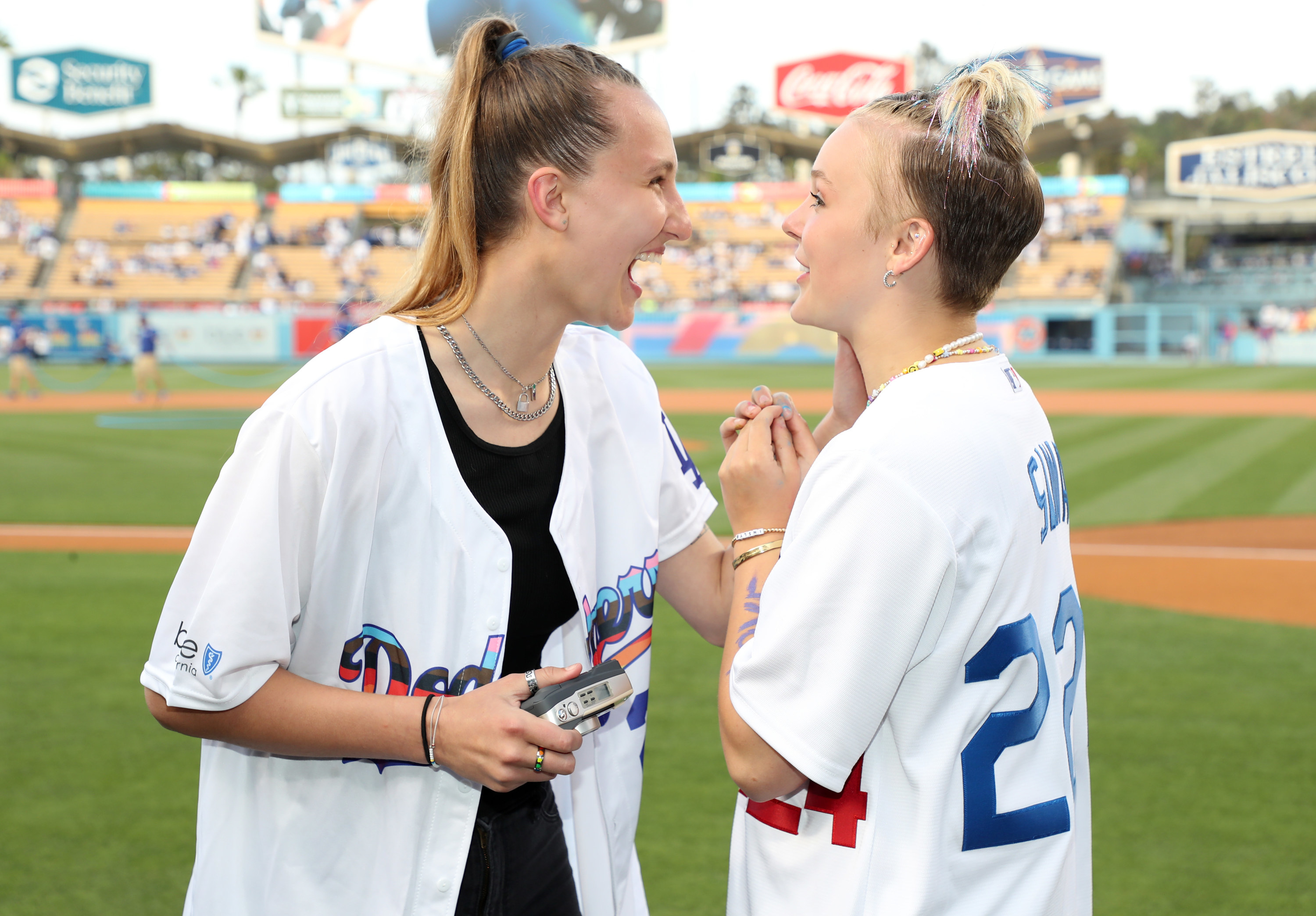 JoJo and Kylie standing on the field and laughing together