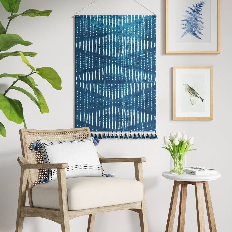 An image of a wall tapestry with tassels hanging on a wall