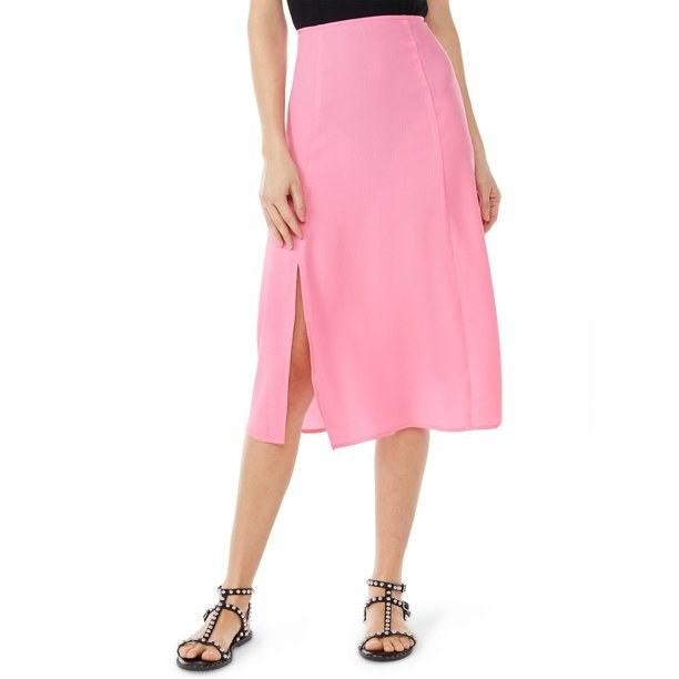 Model wearing pink skirt, black shoes and black top