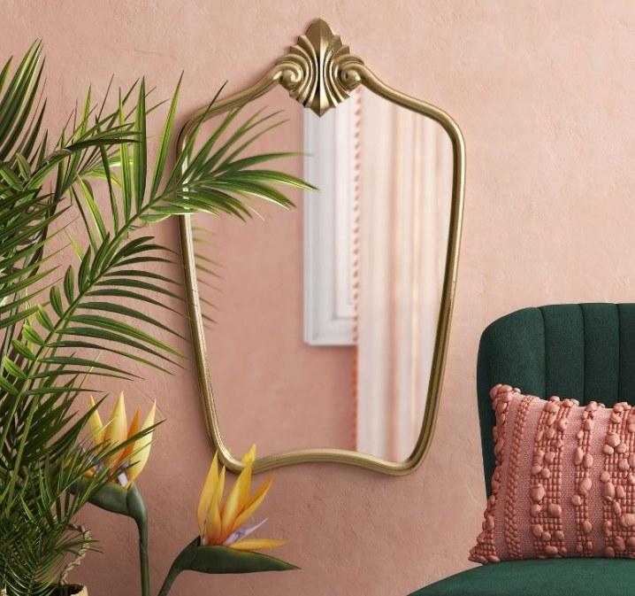 Gold mirror on pink wall