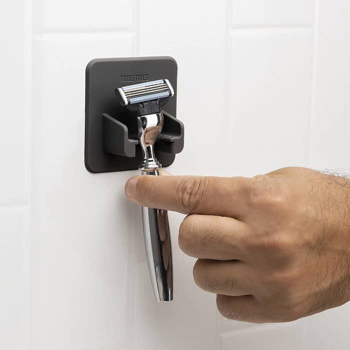 a person reaching for their razor that&#x27;s hung on the razor mount
