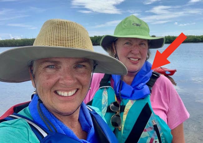 two reviewers wearing sun hats and a blue towels around their neck 