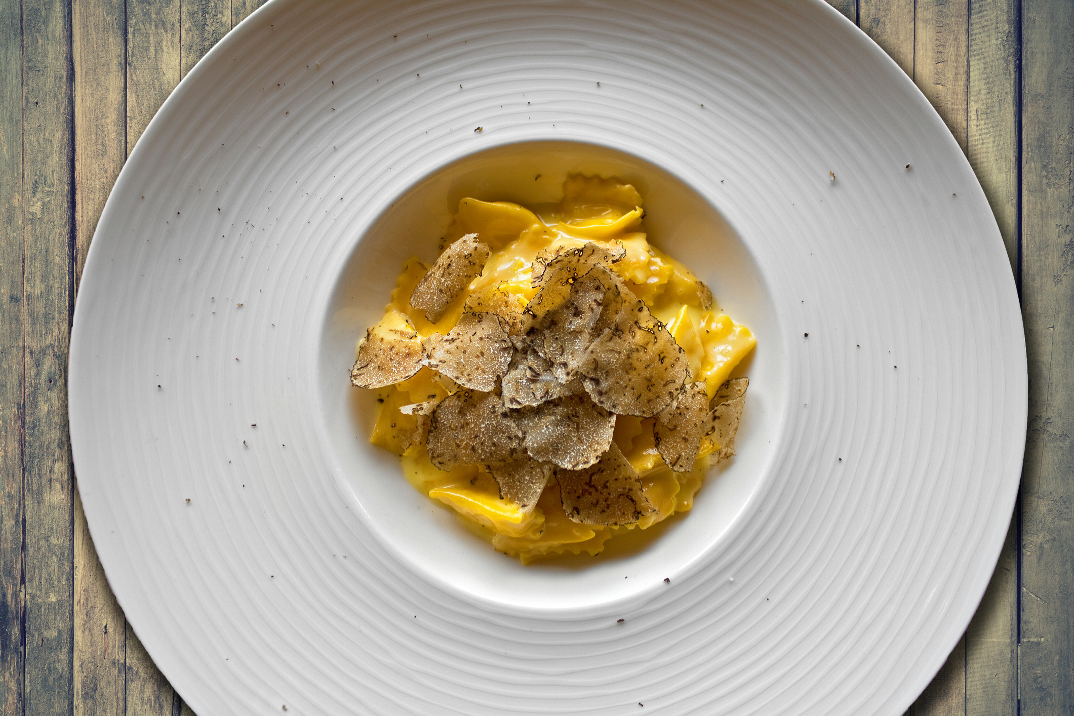 Ravioli pasta dish with cheese sauce and black truffles