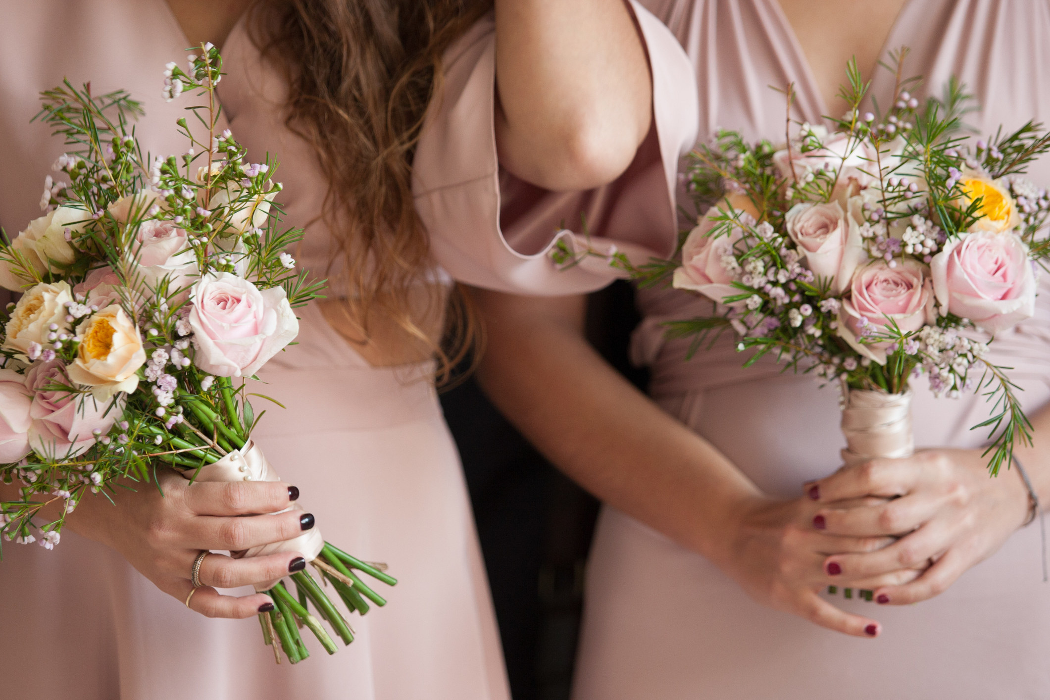 close up of two bridesmaids holding bouquets