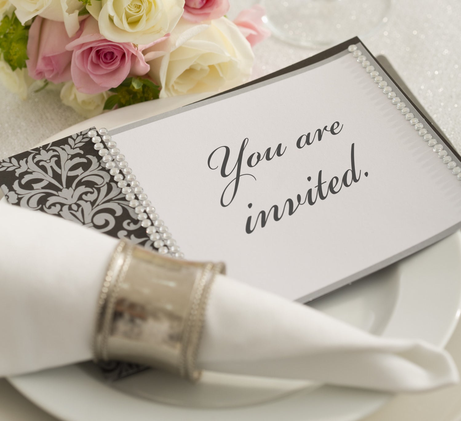 a table setting with an invite on the plate