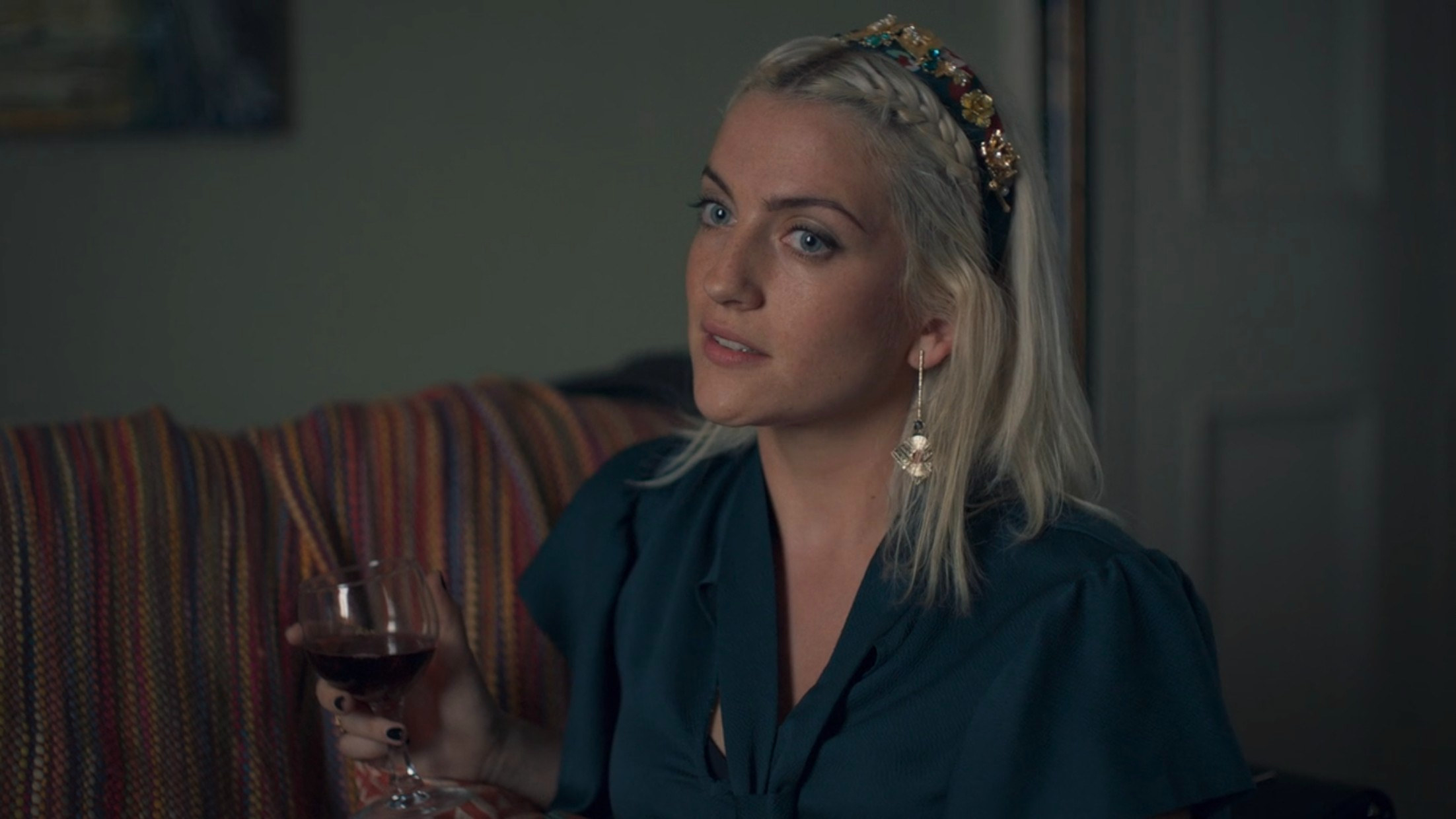 India Mullen as Peggy in Normal People, holding a glass of red wine