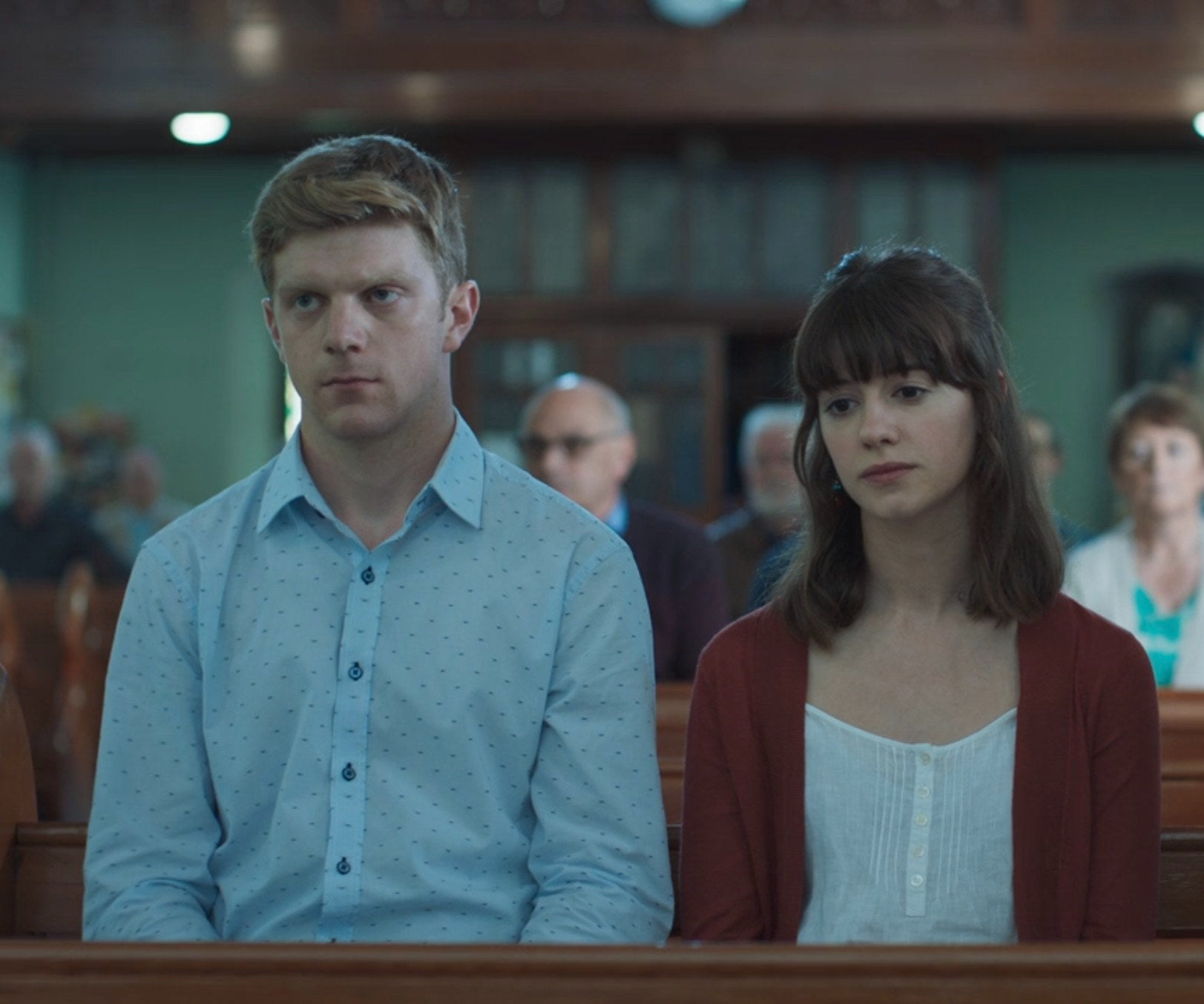 Frank Blake as Alan and Daisy Edgar-Jones as Marianne sitting in church pews on Normal People