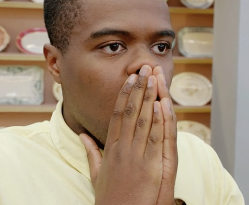 A man covering his face looking shocked