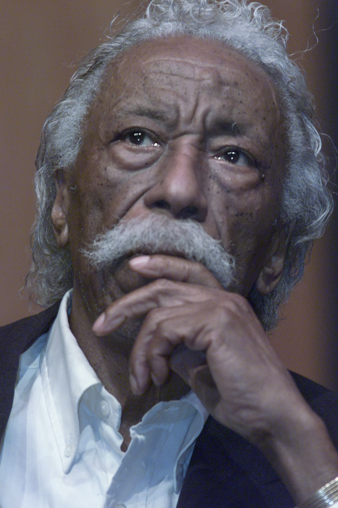 Gordon Parks sits with his hand to his chin