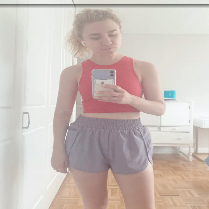 Emma posing in a tank top and the shorts