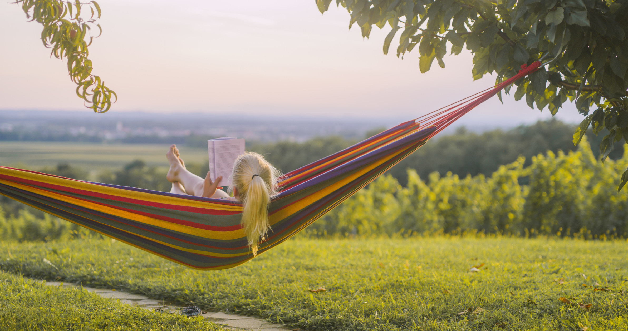 Woman reading a book in hammock in the nature.