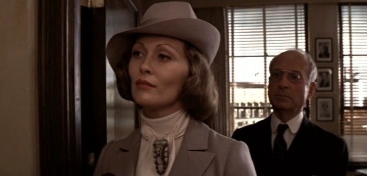 Evelyn standing in an office with a man behind her in &quot;Chinatown&quot;